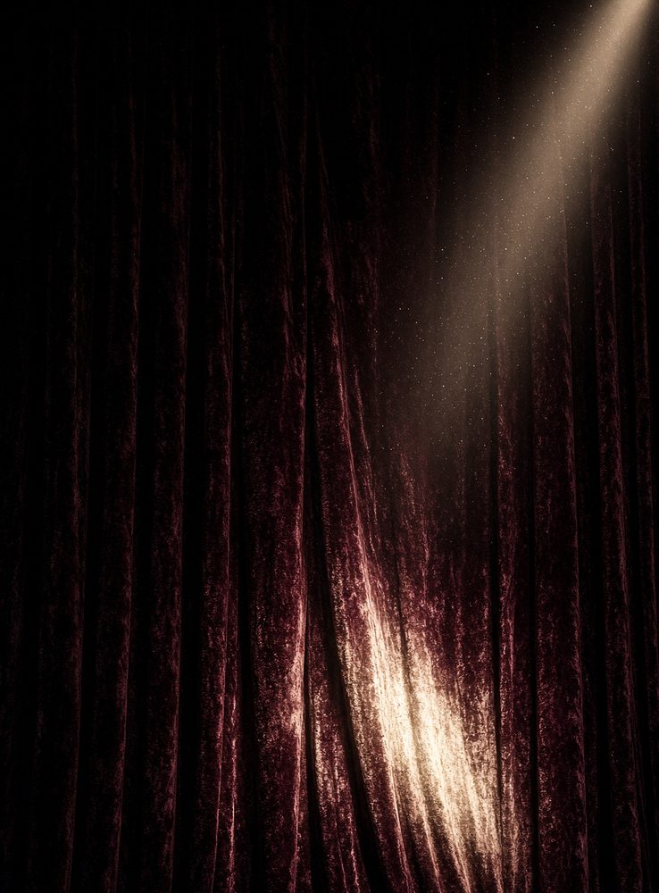 Velvet theatre curtain with a cream spotlight